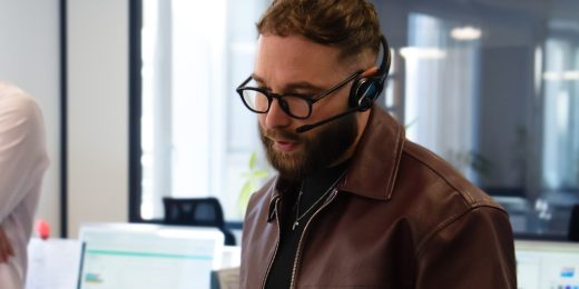 Conseiller du Cabinet Boman, casque sur les oreilles, renseignant un assuré sur ses garanties optique