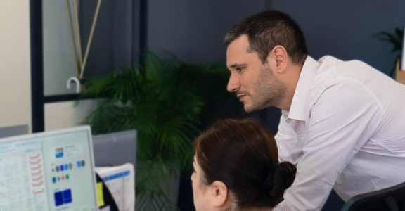 Conseiller du Cabinet Boman accompagnant une cliente devant son écran, dans les bureaux de Nice