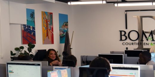 Conseillers du Cabinet Boman au travail dans l'open space de Nice, sous le logo du cabinet