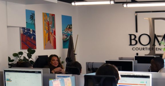 Conseillers du Cabinet Boman au travail dans l'open space de Nice, sous le logo du cabinet